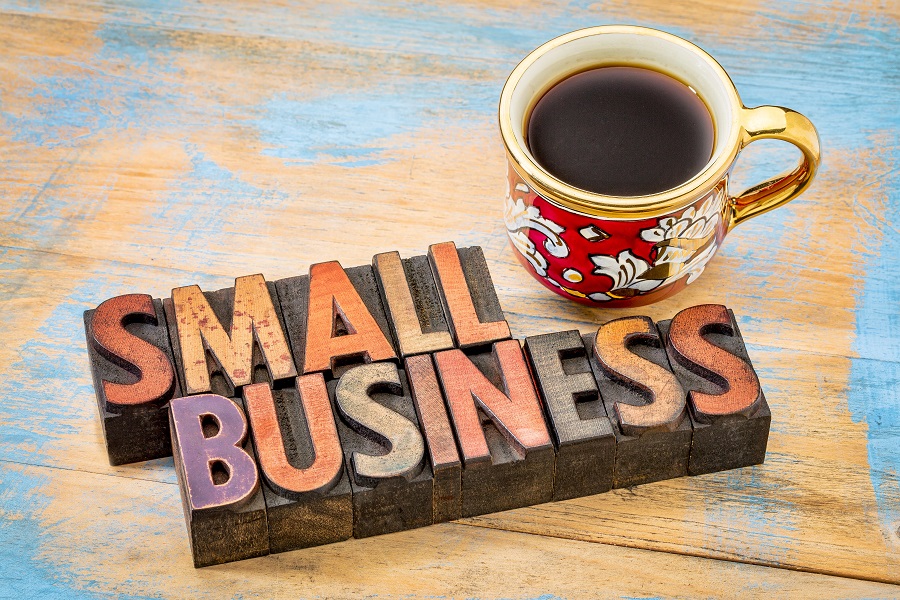small business - text in vintage letterpress wood type printing blocks with a cup of coffee